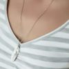 Collier en acier inoxydable avec pendentif feuille argenté, porté avec une chaîne délicate, parfait pour un look élégant et tendance pour femmes.