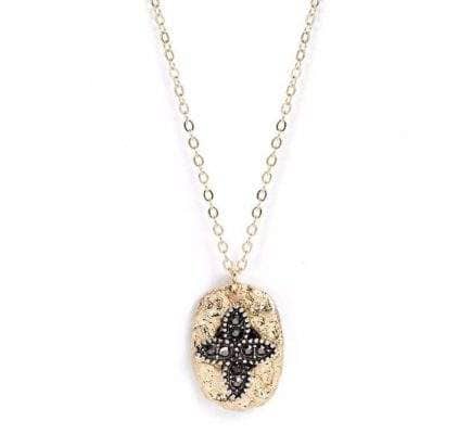 Bijou sautoir chaîne fine en or avec pendentif ovalé en métal doré orné d'une croix en perles noires et cristaux, style bohème chic, parfait pour un accessoire tendance et raffiné.